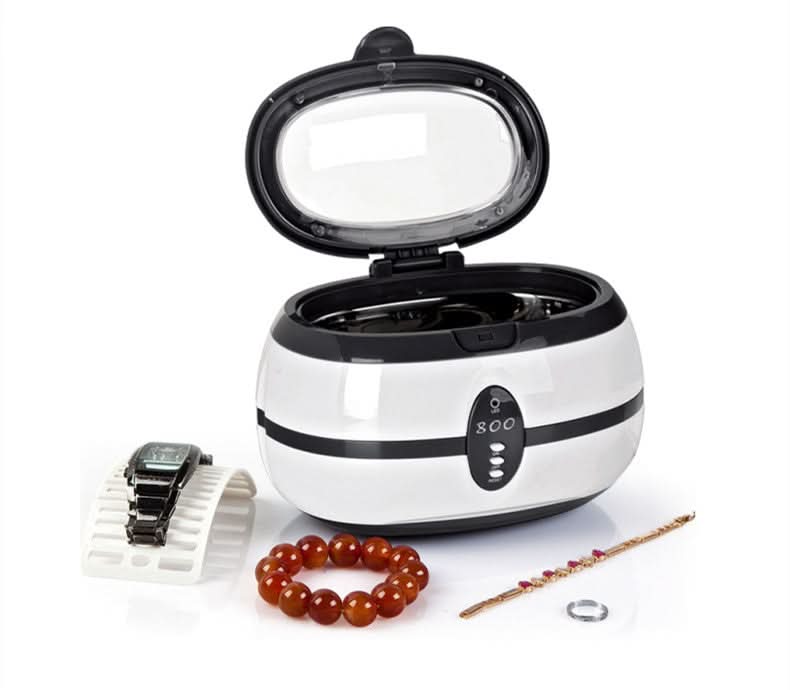 Pulitore ultrasonico per occhiali e gioielli, 35W, coperchio aperto, bracciale e orologio accanto.