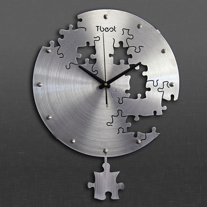 Orologio da parete circolare in metallo spazzolato con motivi puzzle tagliati e pendolo a forma di pezzo di puzzle