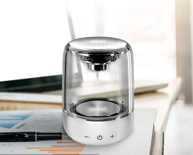Altoparlante portatile Bluetooth con corpo trasparente, base bianca e pulsanti, LED a colori variabili