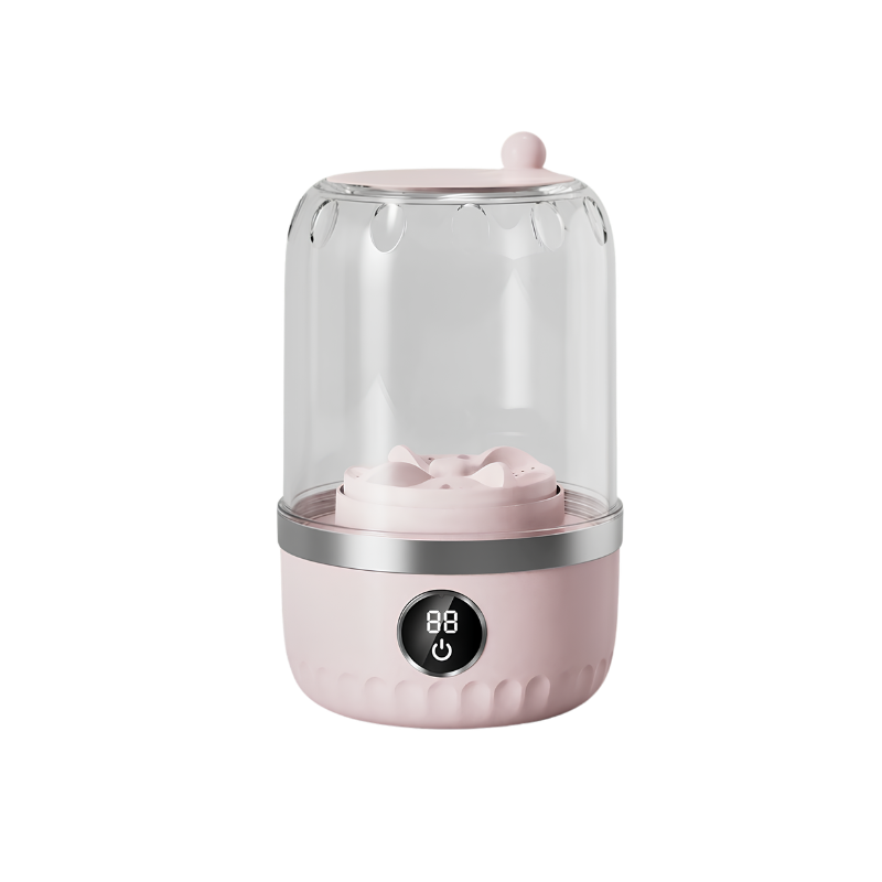 Mini lavatrice compatta rosa con cilindro trasparente e display digitale, ideale per lavanderia portatile e bucato delicato.