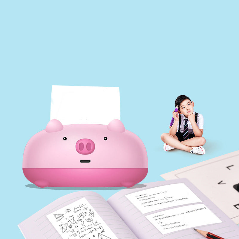 Stampante mini HD a forma di maialino rosa che stampa su carta 58 mm, con una bambina accanto.