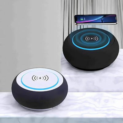Due altoparlanti Bluetooth rotondi con anello LED blu, smartphone poggiato sull'altoparlante superiore.