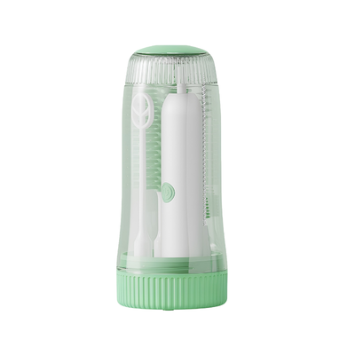 Set pulizia elettrica baby con spazzole per biberon e tettarelle, custodia trasparente verde e sterilizzazione UV integrata.